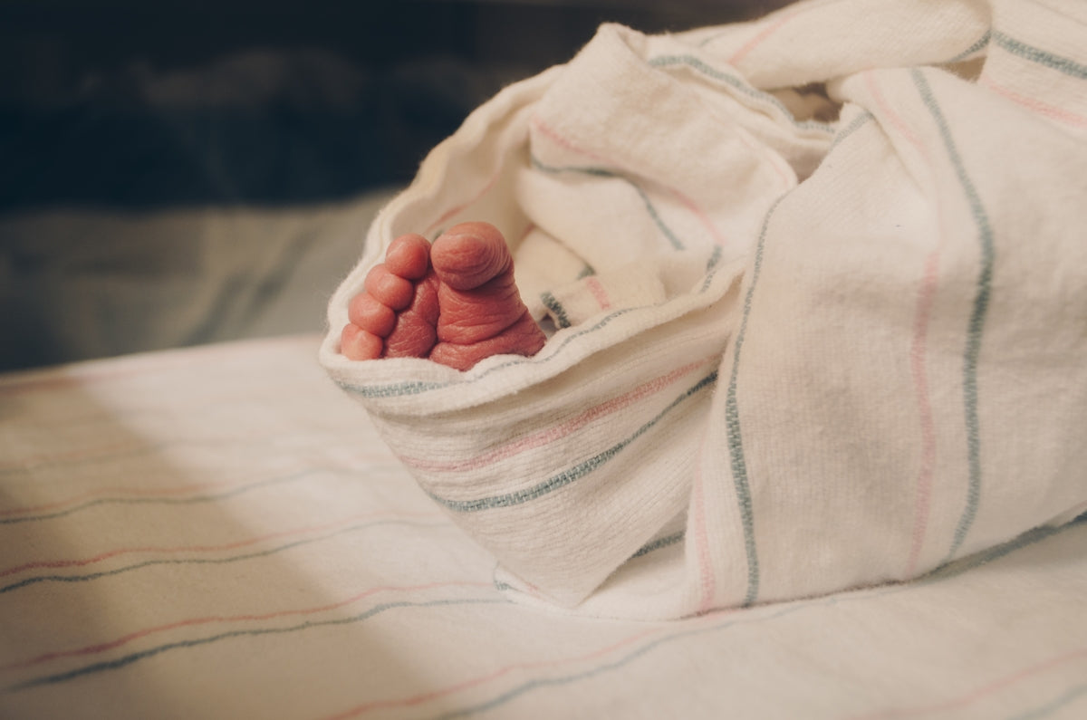 a close up of a person's hand under a blanket