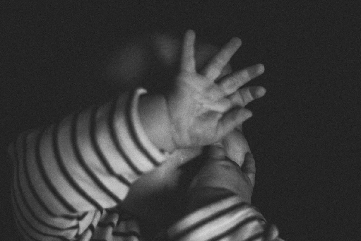 a black and white photo of a baby's hands