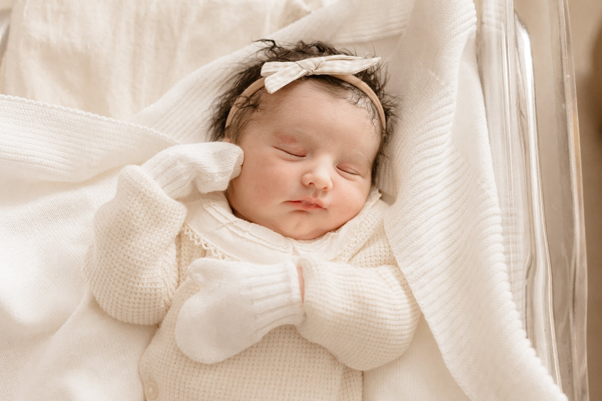 a baby wrapped in a blanket sleeping in a crib