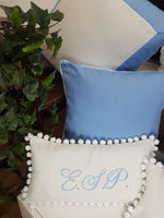 Cuscino rettangolare in cotone bianco con pon pon