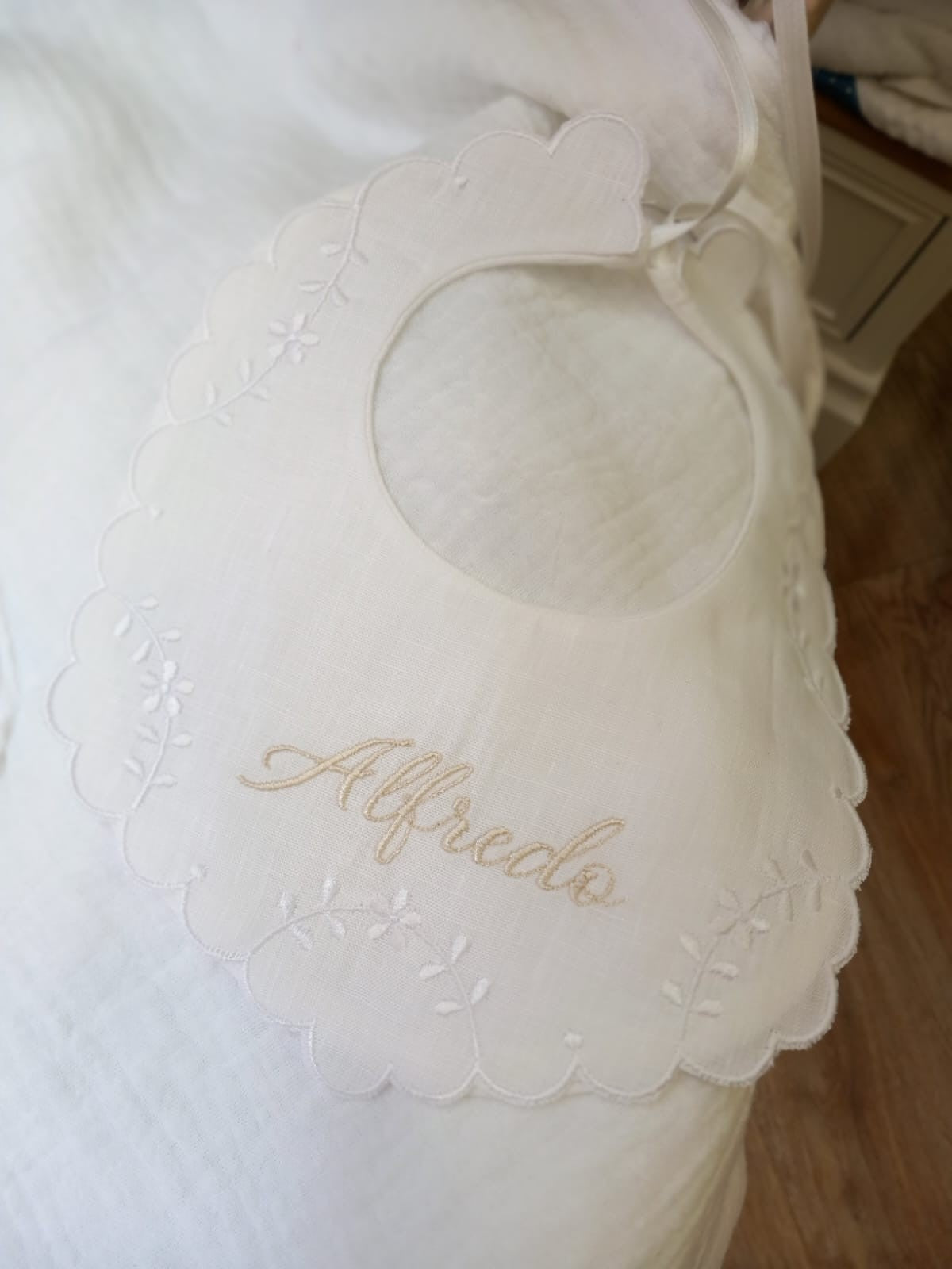 Bavaglino in lino bianco con smerlo e ricami di fiori