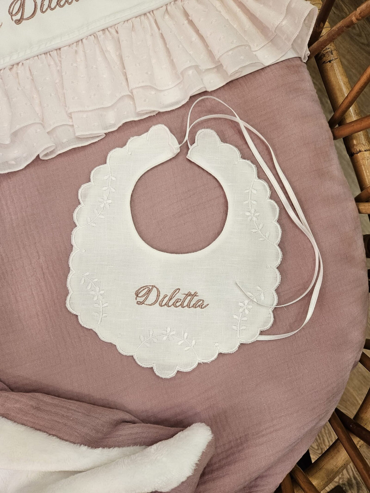 Bavaglino in lino bianco con smerlo e ricami di fiori