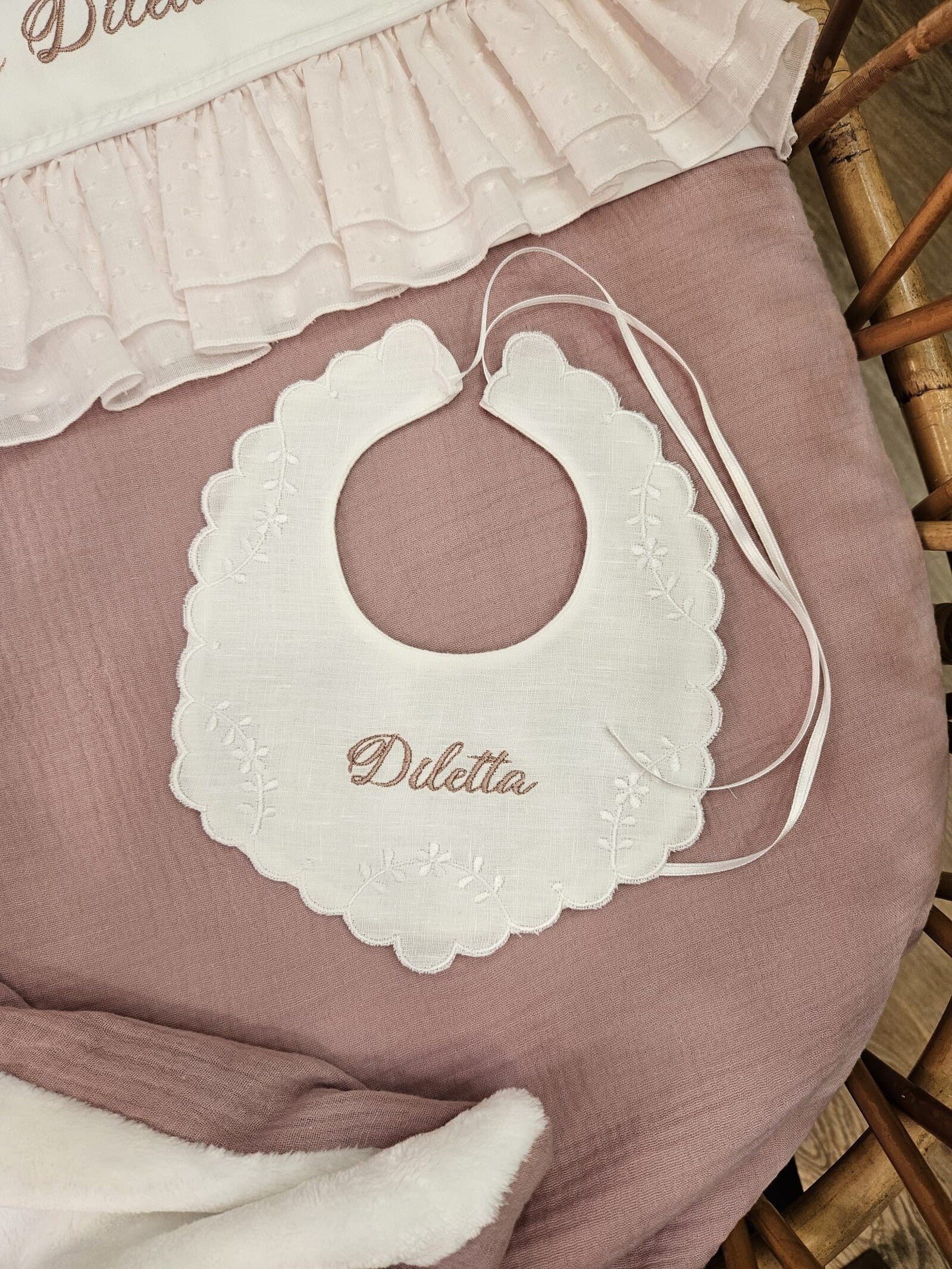 Bavaglino in lino bianco con smerlo e ricami di fiori