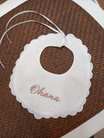 Bavaglino in lino bianco con smerlo e ricami di fiori