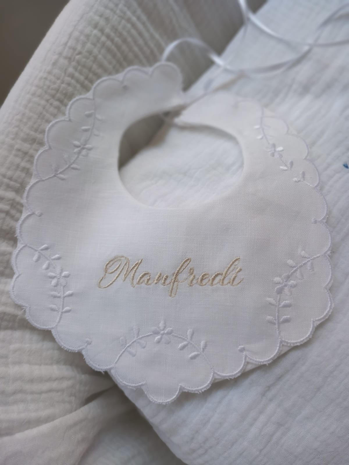 Bavaglino in lino bianco con smerlo e ricami di fiori