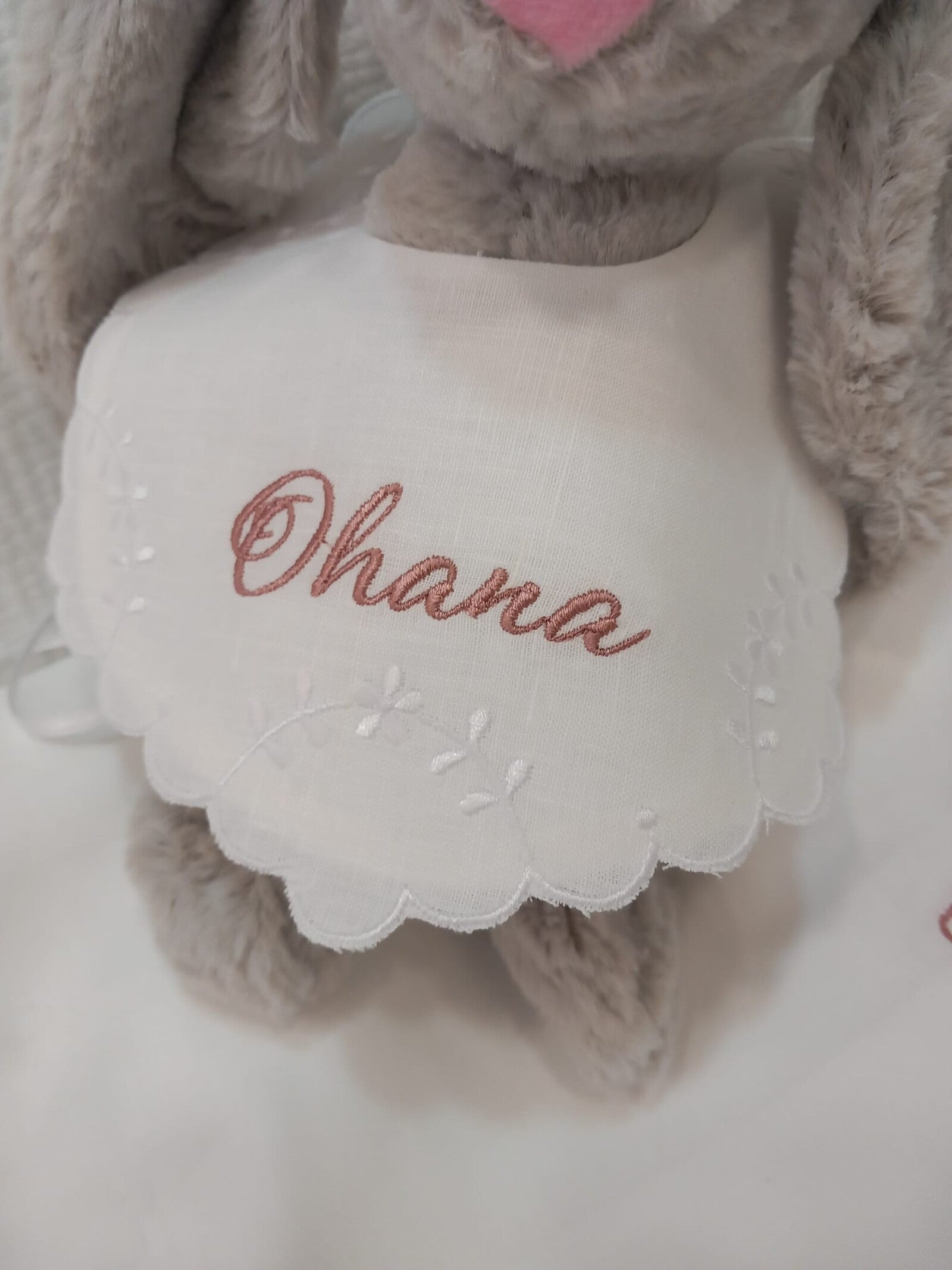 Bavaglino in lino bianco con smerlo e ricami di fiori