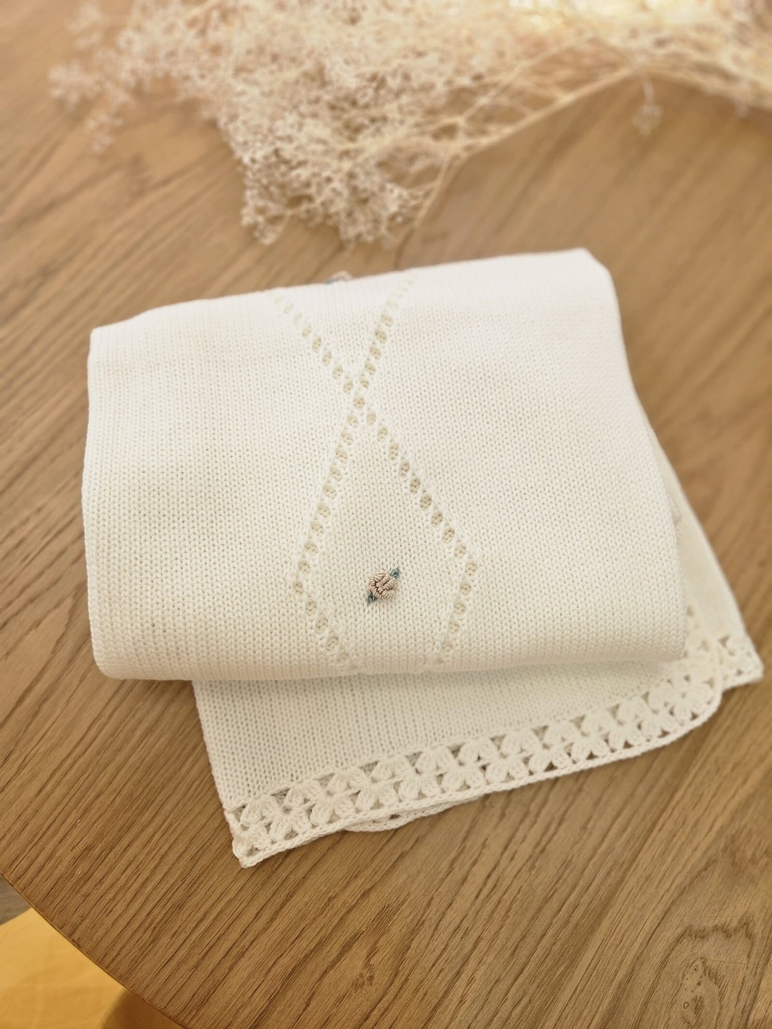 Copertina neonato in lana con traforo centrale e fiorellini
